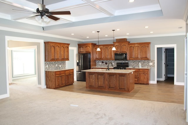 kitchen with black appliances, brown cabinetry, light countertops, and a sink