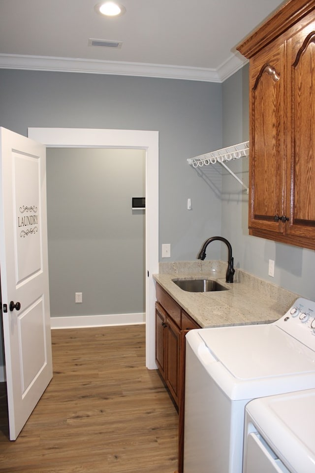 laundry room featuring visible vents, independent washer and dryer, a sink, cabinet space, and crown molding