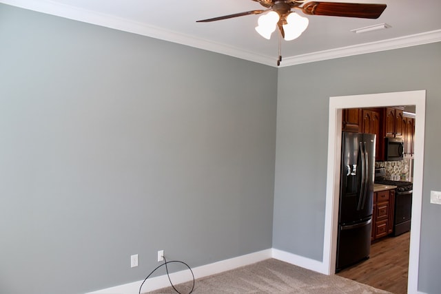 empty room featuring crown molding, a ceiling fan, baseboards, and light carpet