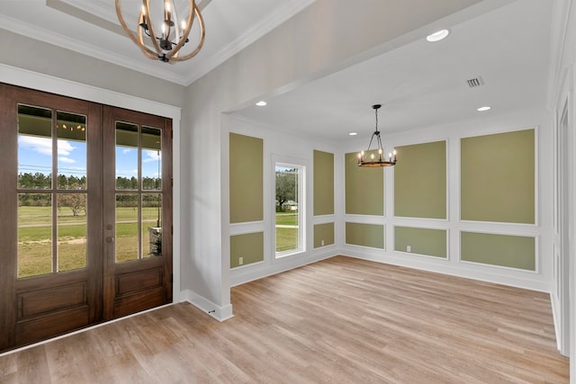 foyer entrance featuring visible vents, an inviting chandelier, crown molding, french doors, and light wood-type flooring