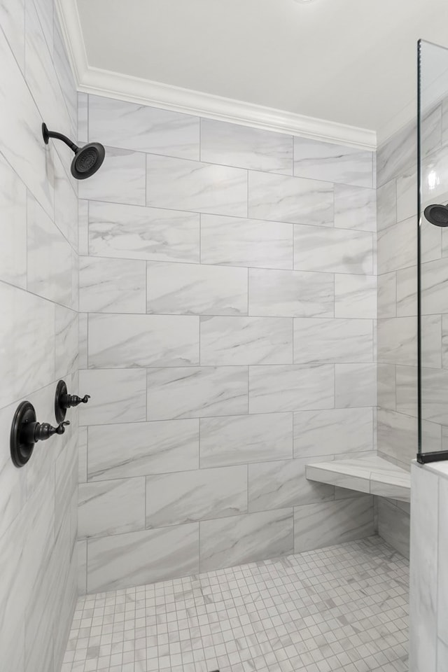 full bathroom featuring tiled shower and crown molding