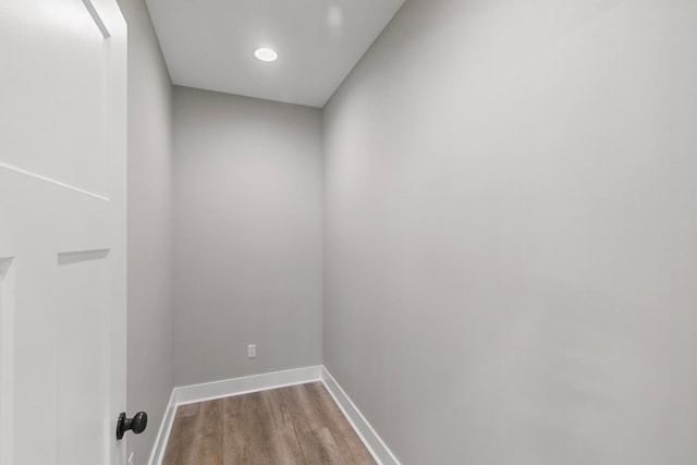 laundry area featuring baseboards and wood finished floors