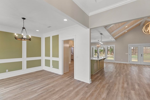 spare room featuring a chandelier, french doors, and vaulted ceiling with beams