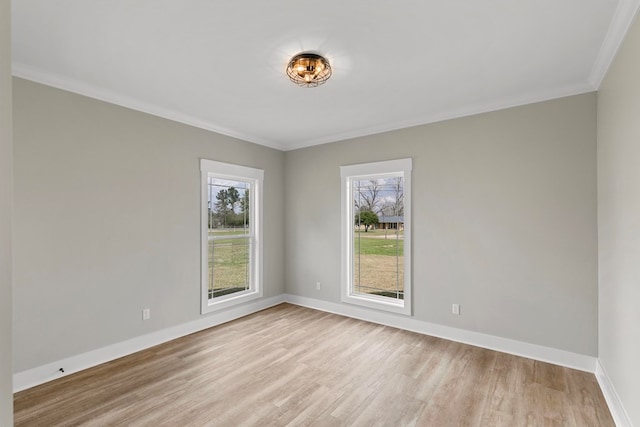 unfurnished room with crown molding, light wood-style flooring, and baseboards