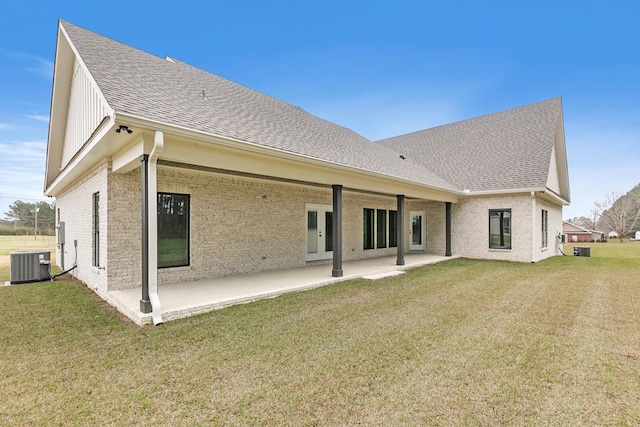 back of property with a yard, a patio, a shingled roof, and cooling unit