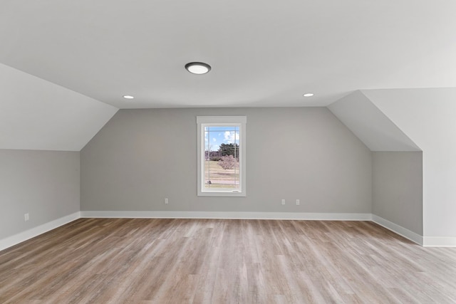 additional living space featuring vaulted ceiling, light wood finished floors, recessed lighting, and baseboards