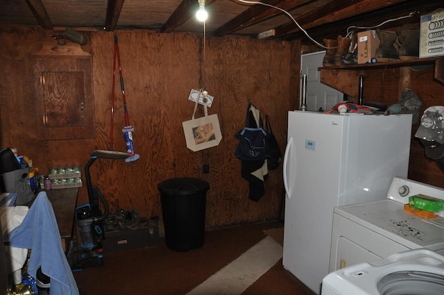 clothes washing area with washer / clothes dryer and wood walls