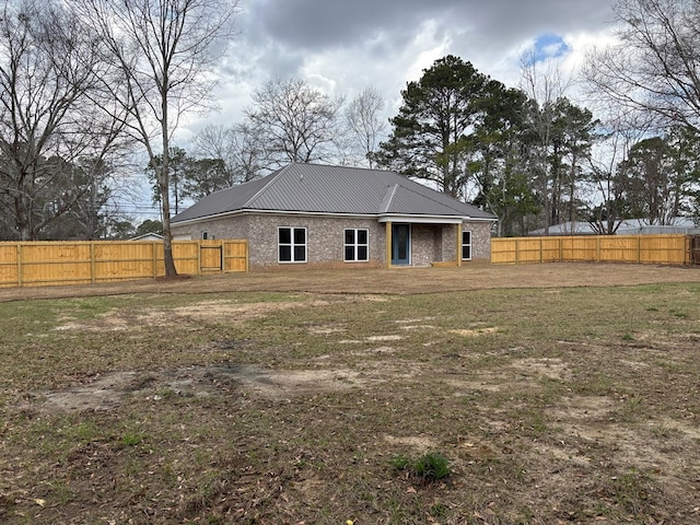 rear view of property featuring a lawn