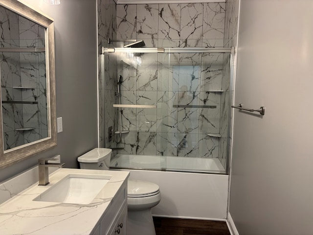 full bathroom featuring vanity, wood-type flooring, shower / bath combination with glass door, and toilet