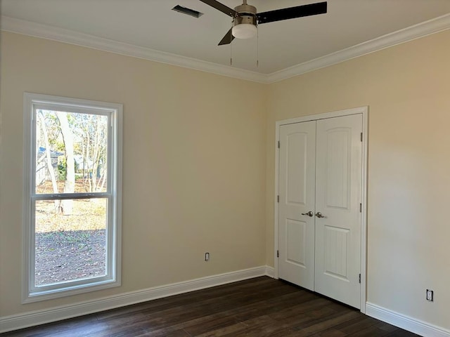 unfurnished bedroom with crown molding, dark hardwood / wood-style floors, ceiling fan, and a closet