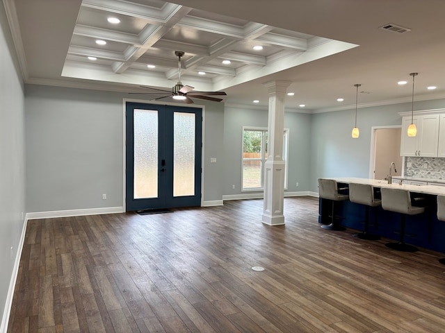 interior space featuring ornamental molding, dark hardwood / wood-style floors, and decorative columns