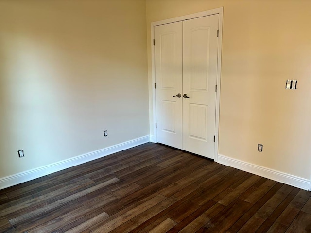 unfurnished bedroom featuring dark wood-type flooring and a closet