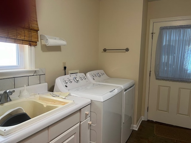 clothes washing area featuring washer and clothes dryer, dark tile patterned floors, and sink