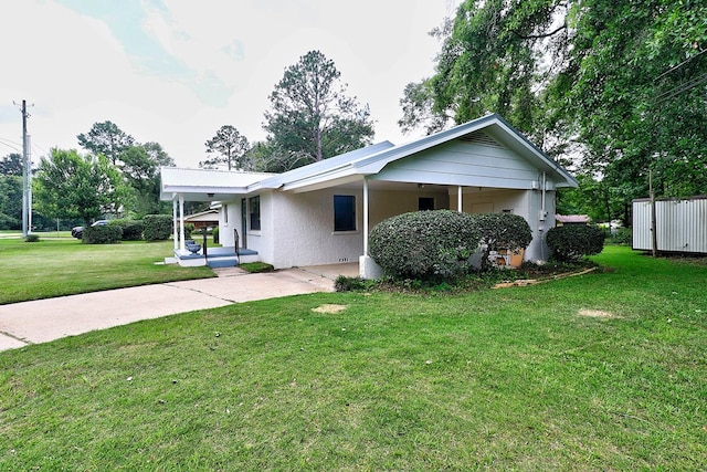 382 Timbers Dr, Dothan, AL 36301 - view of front of house featuring concrete driveway, a front lawn, a carport, and stucco siding