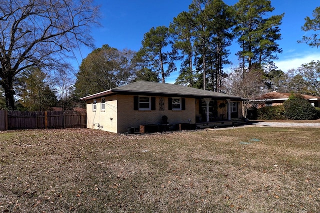 view of front facade featuring brick siding, a front lawn, and fence