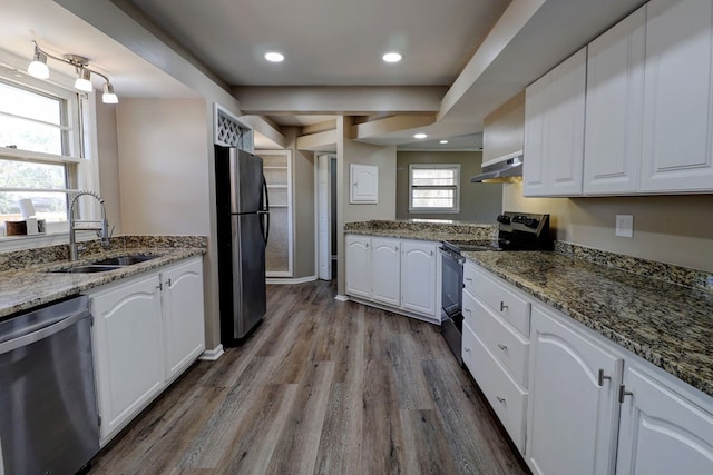 kitchen featuring stainless steel appliances, dark stone countertops, white cabinetry, and sink