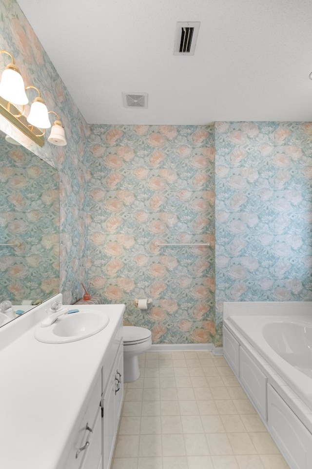 bathroom with vanity, toilet, and a tub