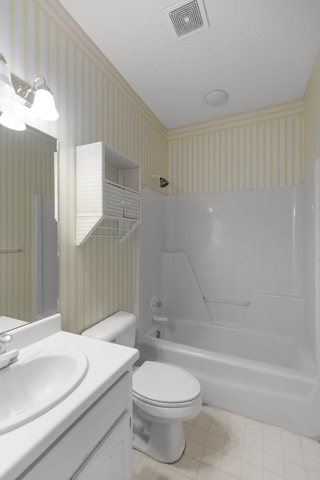 full bathroom featuring bathing tub / shower combination, vanity, a textured ceiling, and toilet