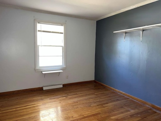 empty room with a wealth of natural light, light wood finished floors, baseboard heating, and ornamental molding