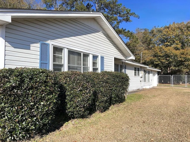 view of home's exterior with fence and a yard