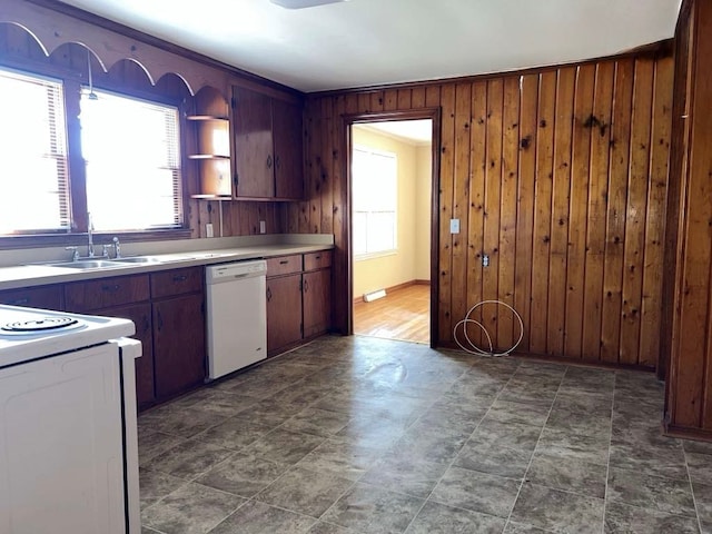 kitchen featuring light countertops, wooden walls, open shelves, a sink, and white appliances