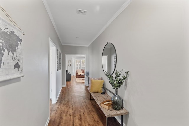 corridor with hardwood / wood-style flooring and ornamental molding