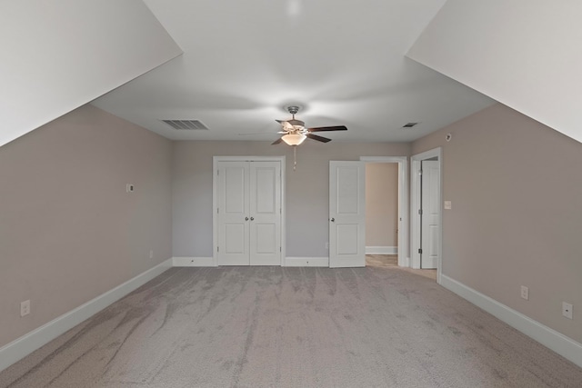 bonus room featuring ceiling fan and light colored carpet