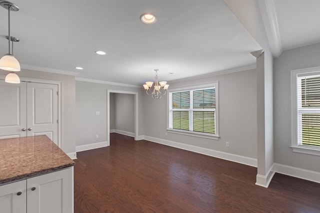 unfurnished dining area with a notable chandelier, dark hardwood / wood-style floors, and ornamental molding