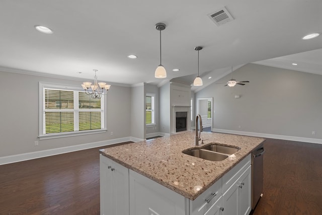 kitchen with ceiling fan with notable chandelier, a kitchen island with sink, sink, decorative light fixtures, and white cabinets