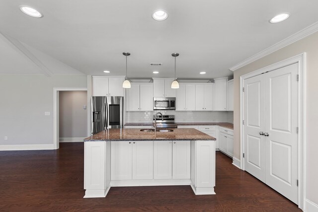 kitchen with a kitchen island with sink, white cabinets, dark stone counters, and appliances with stainless steel finishes