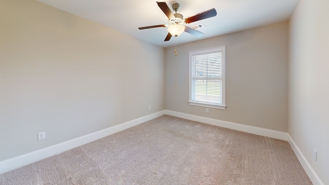 empty room with ceiling fan and light carpet