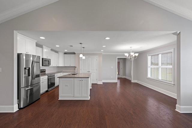 kitchen with white cabinets, appliances with stainless steel finishes, a center island with sink, and hanging light fixtures