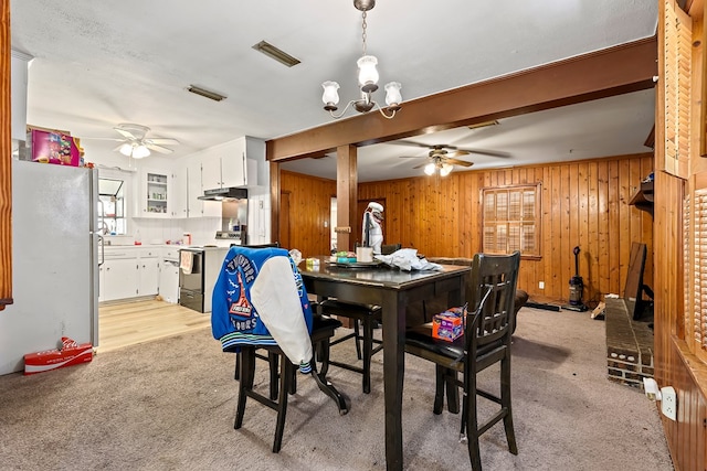 dining room with light carpet, wood walls, and visible vents