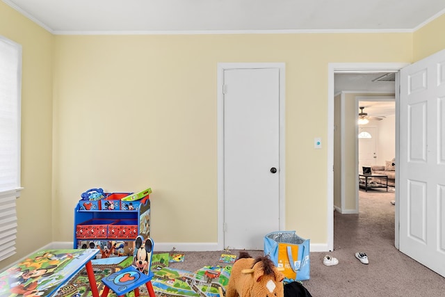 playroom featuring carpet floors, crown molding, and baseboards