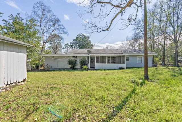 rear view of house featuring a sunroom and a yard