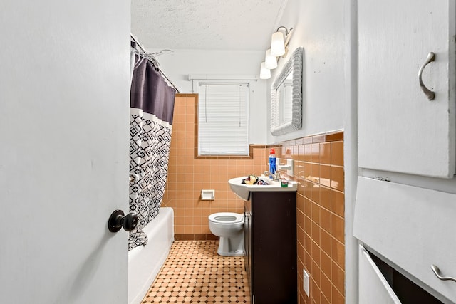 full bath featuring tile walls, toilet, wainscoting, a textured ceiling, and vanity