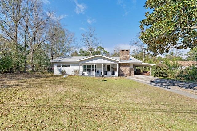 ranch-style home with driveway, a chimney, an attached carport, covered porch, and a front yard