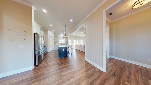 kitchen with a center island, stainless steel refrigerator, a kitchen breakfast bar, pendant lighting, and white cabinets