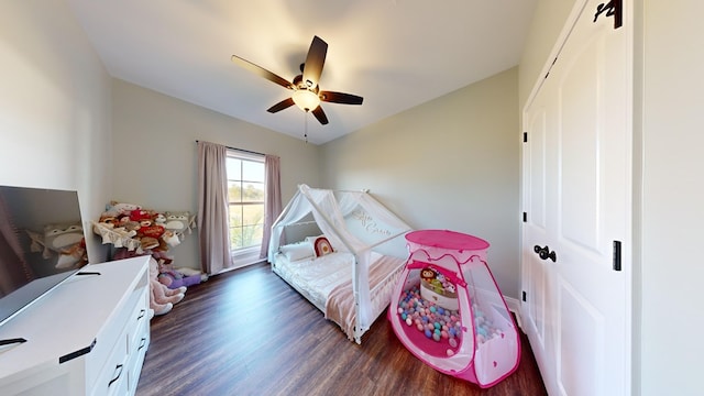 bedroom featuring dark wood-type flooring, ceiling fan, and a closet