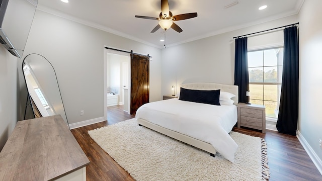 bedroom featuring dark hardwood / wood-style floors, ornamental molding, ceiling fan, a barn door, and ensuite bath