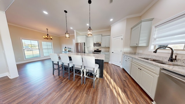 kitchen with stainless steel appliances, sink, white cabinets, and a spacious island