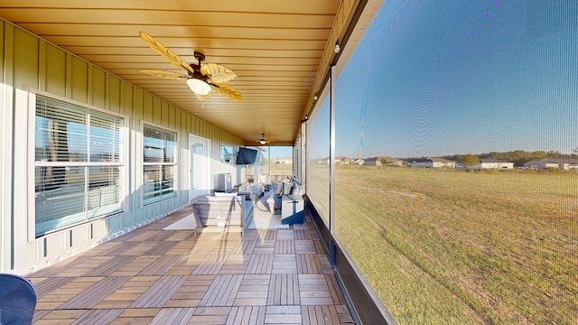 unfurnished sunroom featuring ceiling fan