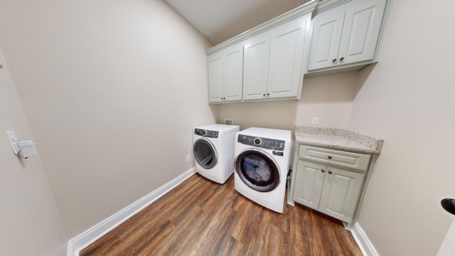 clothes washing area featuring cabinets, dark wood-type flooring, and independent washer and dryer