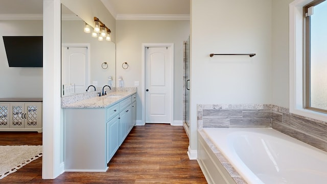 bathroom featuring hardwood / wood-style flooring, ornamental molding, plus walk in shower, and vanity