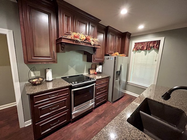 kitchen with stone countertops, sink, appliances with stainless steel finishes, and dark wood-type flooring