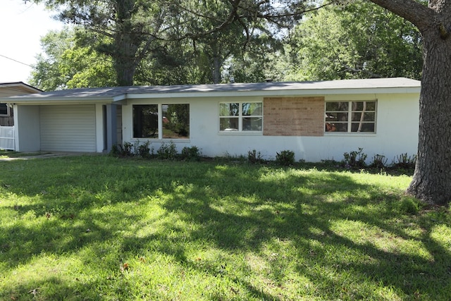 ranch-style house featuring an attached carport and a front lawn