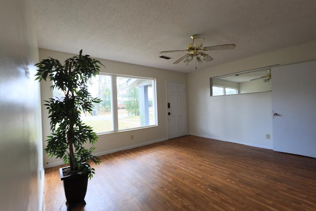 empty room with wood-type flooring, a textured ceiling, and ceiling fan