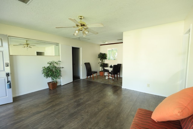 living area with a textured ceiling, wood finished floors, baseboards, and a ceiling fan