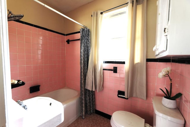 bathroom with tile patterned flooring, toilet, tile walls, and shower / tub combo with curtain