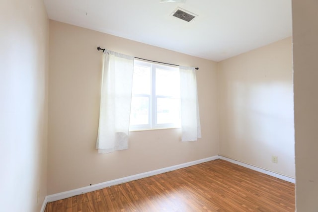 unfurnished room with wood-type flooring